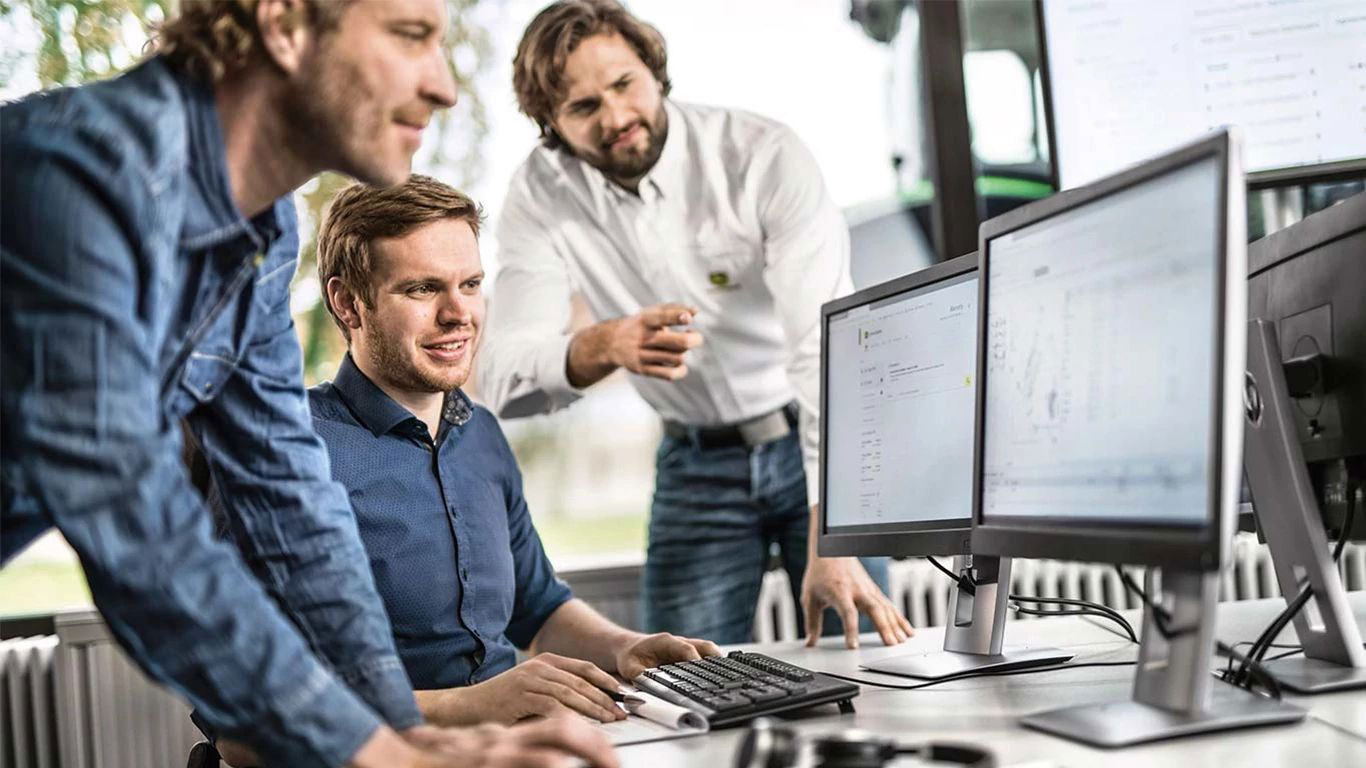 John Deere service specialists reviewing connected equipment data